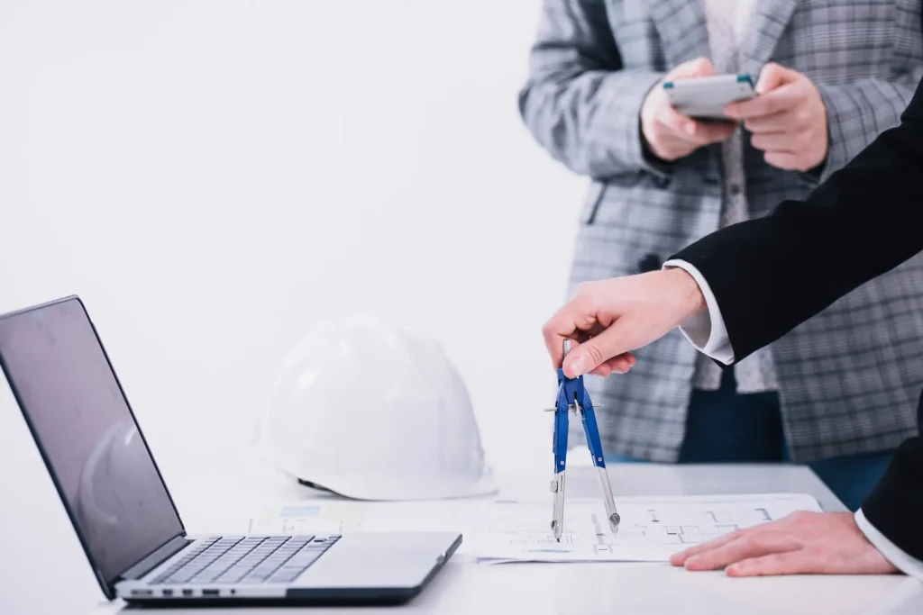 Crop People Working With Plans Near Laptop