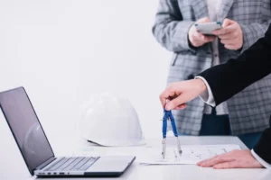 Crop People Working With Plans Near Laptop